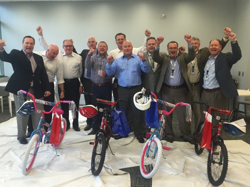 Group having fun at a Build-A-Bike team building event by The Leaders Institute.
