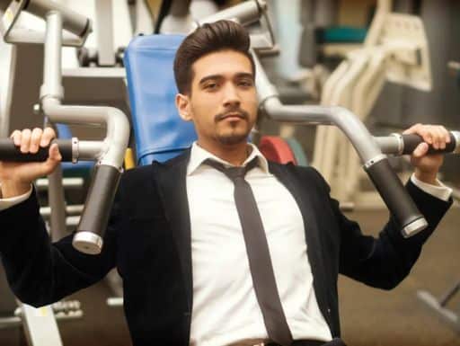 Guy in business suit using gym machine