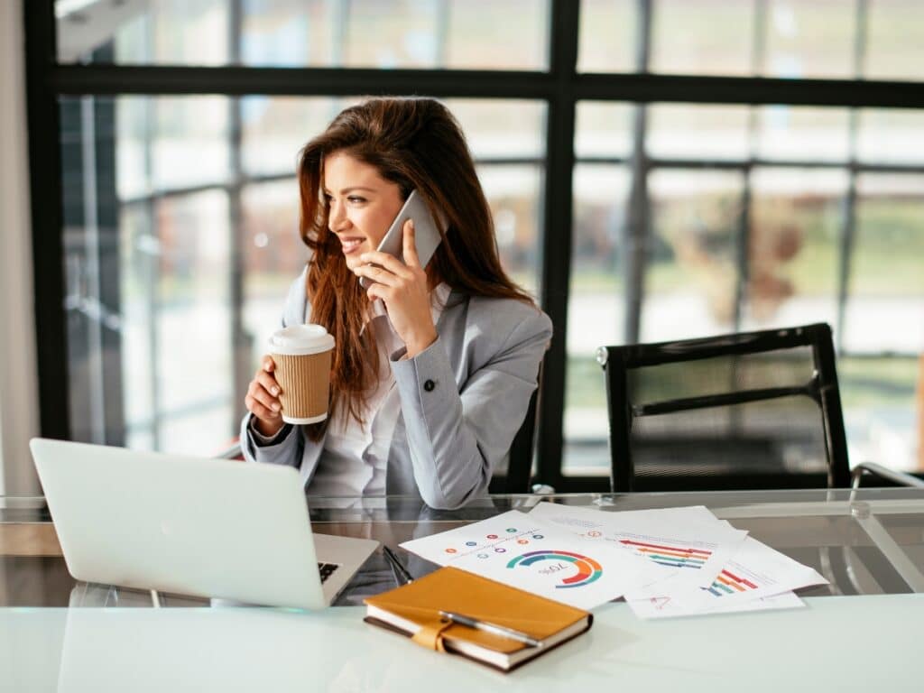 Confident and content business woman multi-tasking on work project.