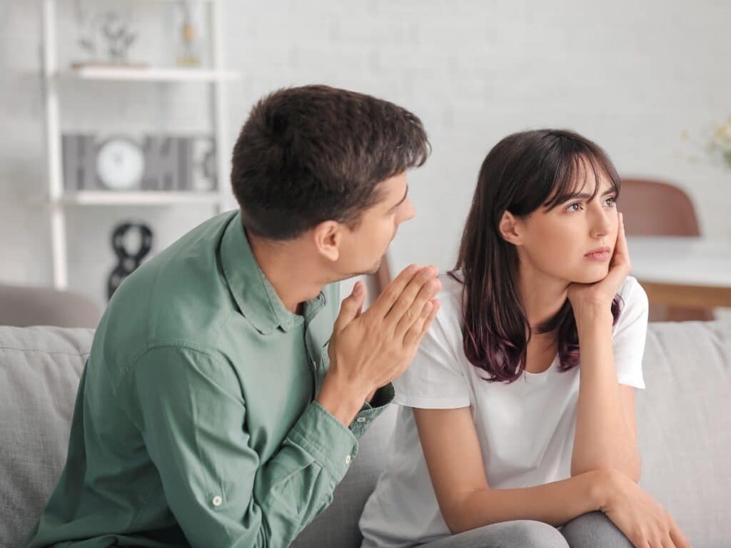 Man pleading for forgiveness from woman who does not want to talk.