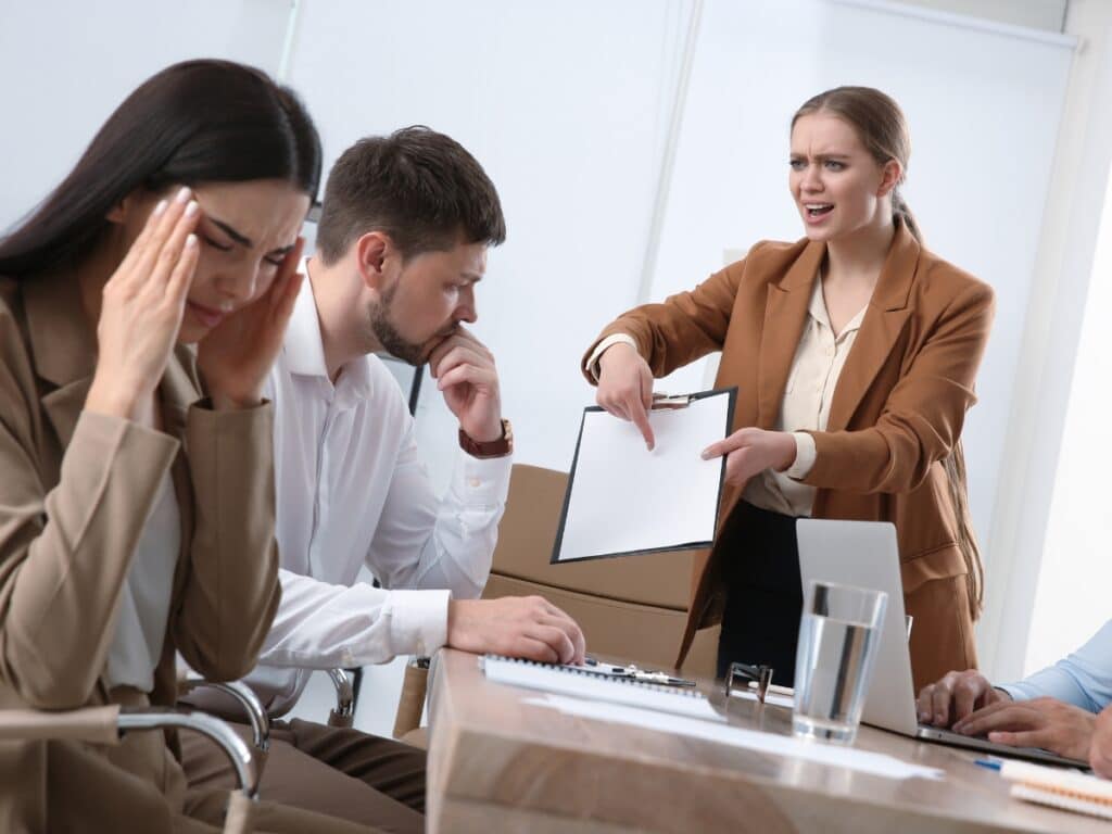 Manager lashing out at subordinates in work meeting.